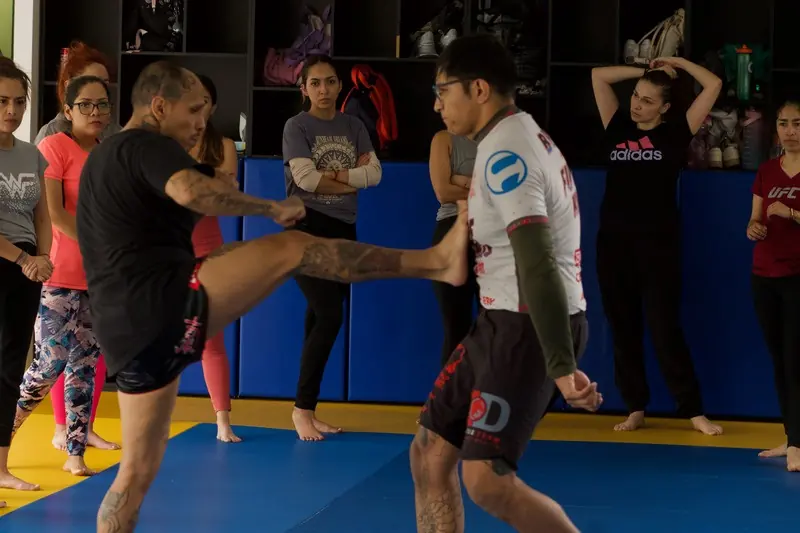 Instructor y alumno practicando una defensa contra patada